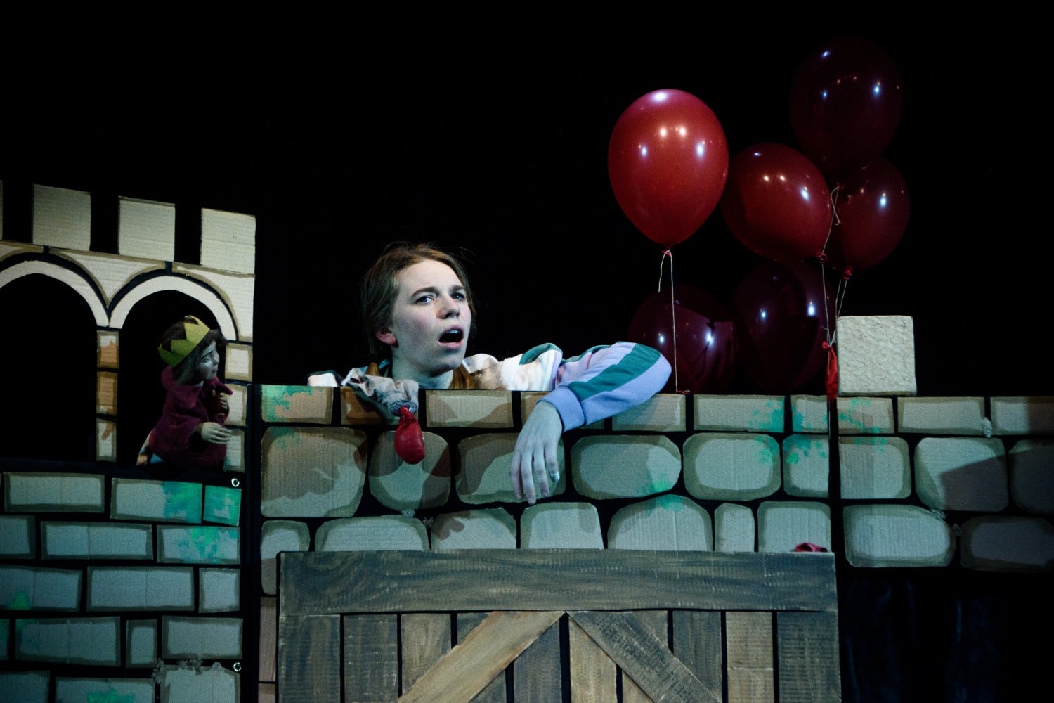 Eine Schlossmauer aus Pappe, darüber schaut eine Frau